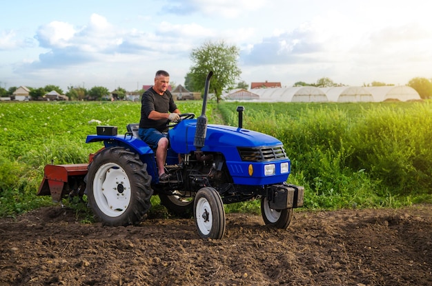 Farmer on a tractor works in the field Land cultivation Seasonal worker Recruiting and hiring employees for work in the farm Farming agriculture Preparatory earthworks before planting a new crop