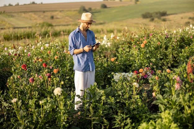 Farmer with phone on flower farm outdoors