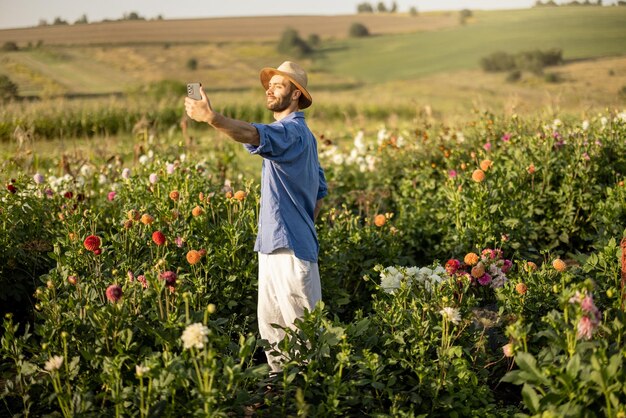 Farmer with phone on flower farm outdoors