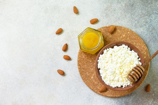 Farmers cheese curd cheese or cottage cheese in a bowl with honey and almond  Top view