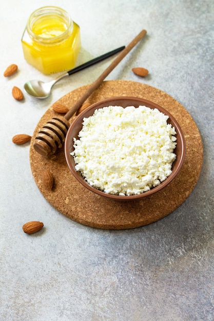 Farmers cheese curd cheese or cottage cheese in a bowl with honey and almond