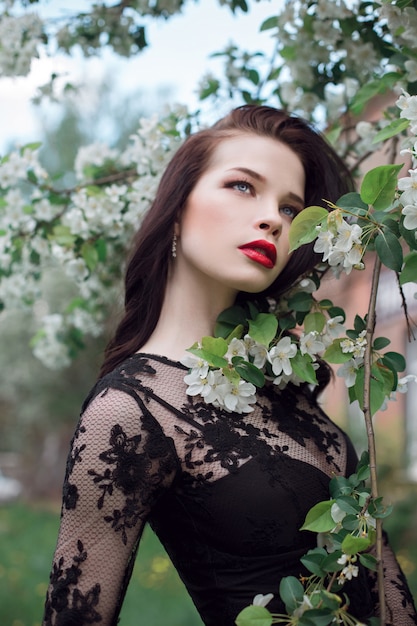 Fashion art Woman in summer blossoming Apple tree