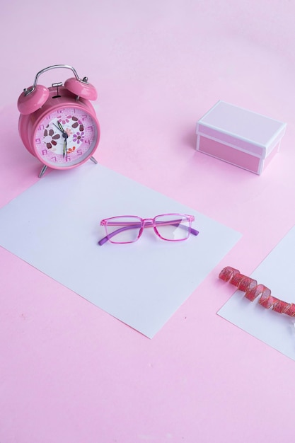 Fashion and beauty concept lying flat with square glasses women's accessories on pink background