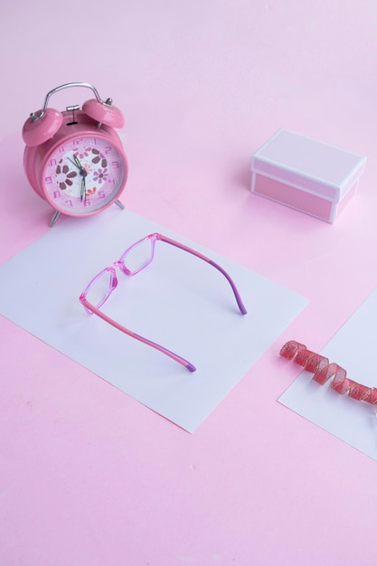 Fashion and beauty concept lying flat with square glasses women's accessories on pink background