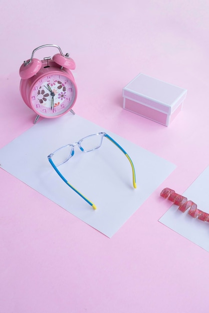 Fashion and beauty concept lying flat with square glasses women's accessories on pink background