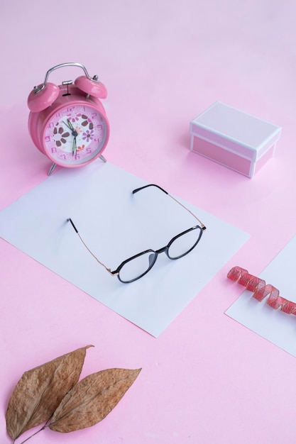 Fashion and beauty concept lying flat with square glasses women's accessories on pink background