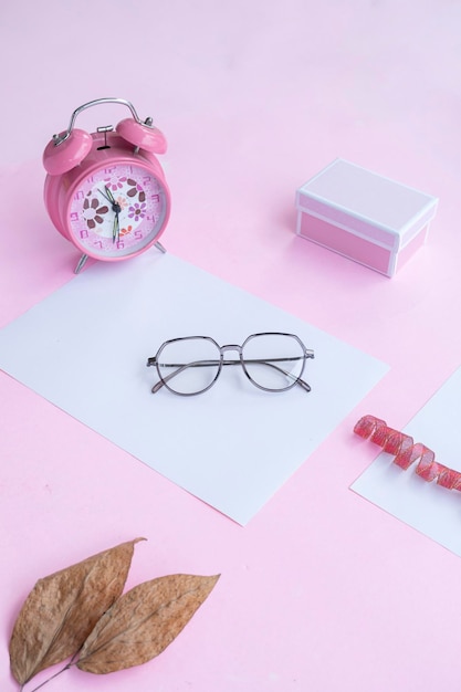 Fashion and beauty concept lying flat with square glasses women's accessories on pink background