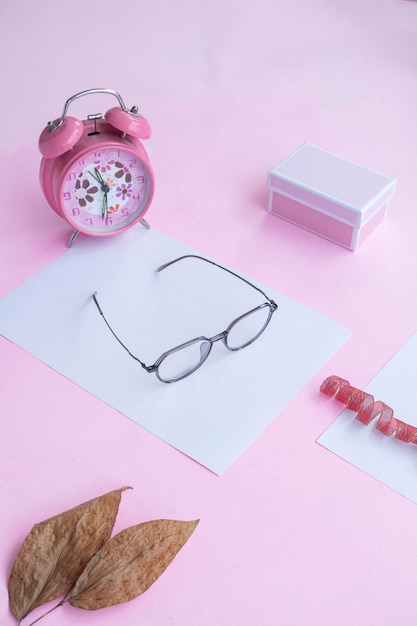 Fashion and beauty concept lying flat with square glasses women's accessories on pink background