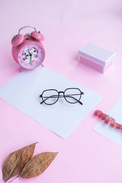 Fashion and beauty concept lying flat with square glasses women's accessories on pink background