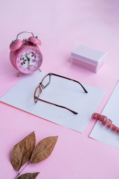 Fashion and beauty concept lying flat with square glasses women's accessories on pink background