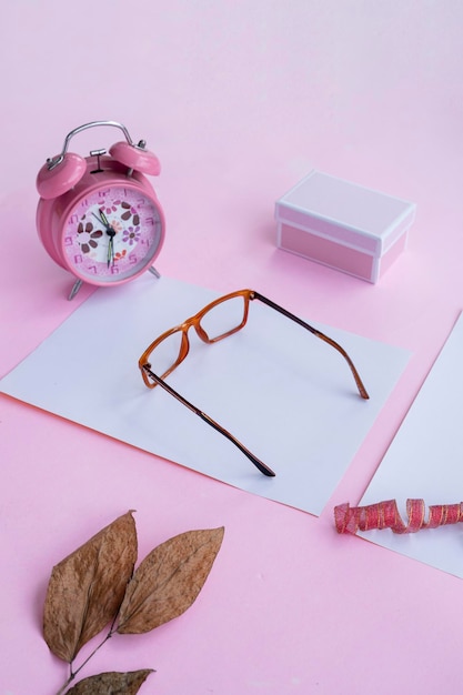 Fashion and beauty concept lying flat with square glasses women's accessories on pink background