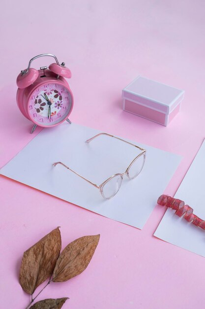 Fashion and beauty concept lying flat with square glasses women's accessories on pink background