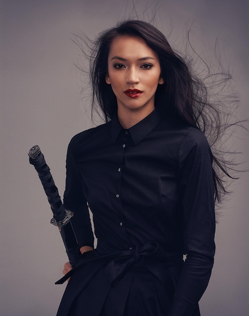 Fashion beauty portrait and warrior woman art with sword to fight for power cosplay and fantasy Strong asian female from Japan in black for makeup and cosmetics for samurai or ninja battle