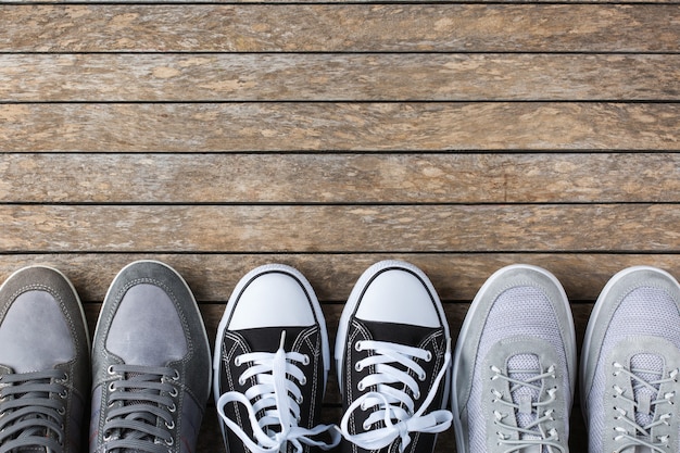 Fashion, blog, blogging, lifestyle, well-being trendy concept. Set of male shoes, sneakers on wooden background, top view, copy space, flat lay