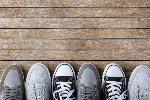 Fashion, blog, blogging, lifestyle, well-being trendy concept. Set of male shoes, sneakers on wooden background, top view, copy space, flat lay