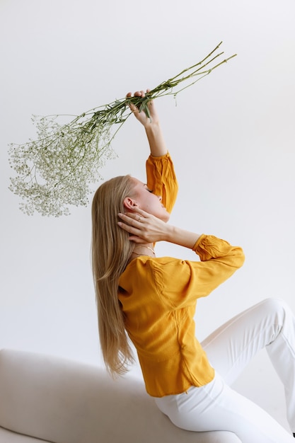 Fashion blogger with dry flowers in a stylish image on a gray background. poster