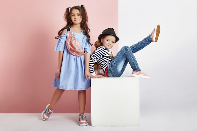 Fashion boy and girl in stylish clothes on colored wall background. Autumn bright clothes on children, a child posing on a colored purple pink background. Russia, Sverdlovsk, 6 April 2019