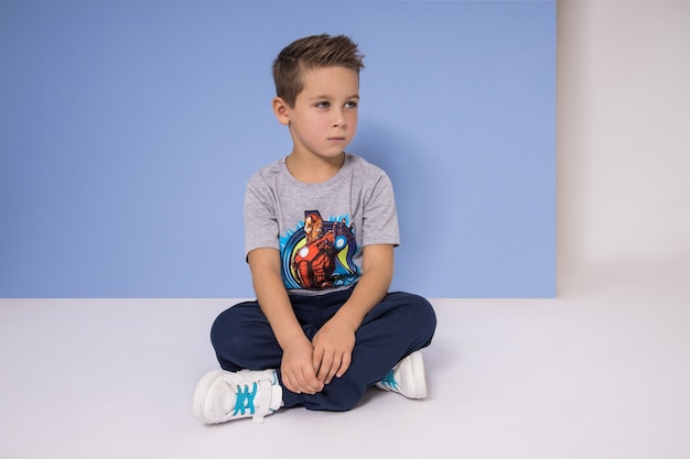 Fashion boy in stylish clothes on colored wall background. Autumn bright clothes on children, a child posing on a colored purple pink background. Russia, Sverdlovsk, 6 April 2019