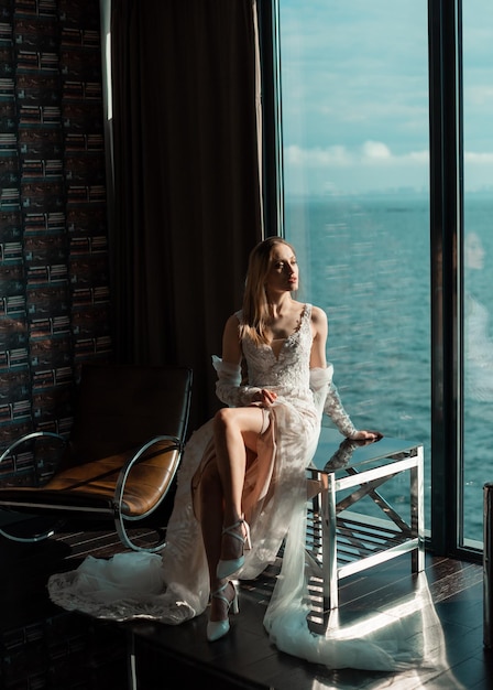 Fashion bride with a long dress near the window Waiting for the groom Wedding interior