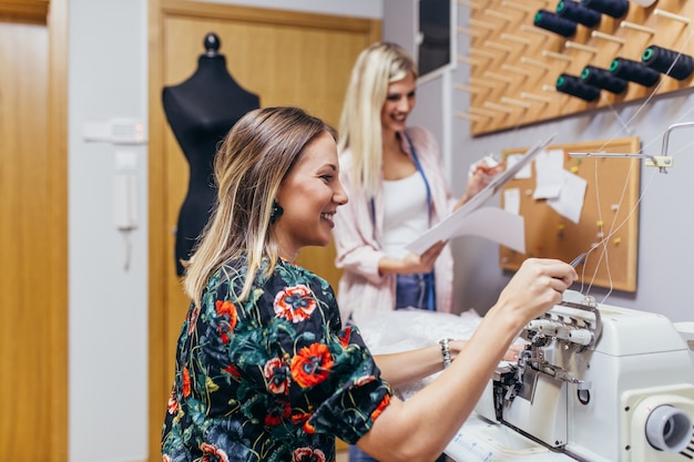 Fashion designers working in salon for sewing wedding dresses.