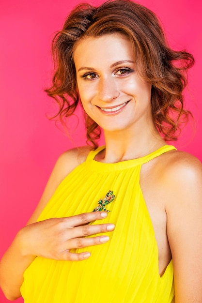 Fashion detail on model in yellow summer dress decorated with colorful dragonfly brooch accessory Women's fashion