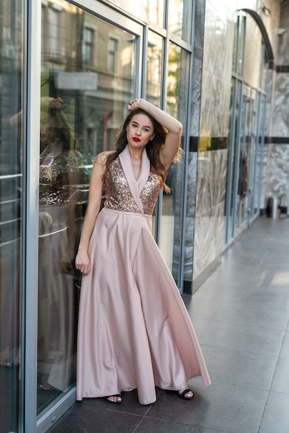 Fashion full-length portrait pretty lady in attractive ball gown dress at city street