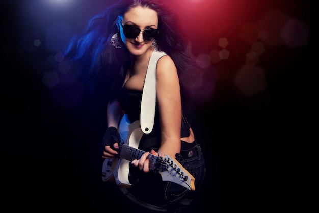 Fashion girl with guitar playing hard rock