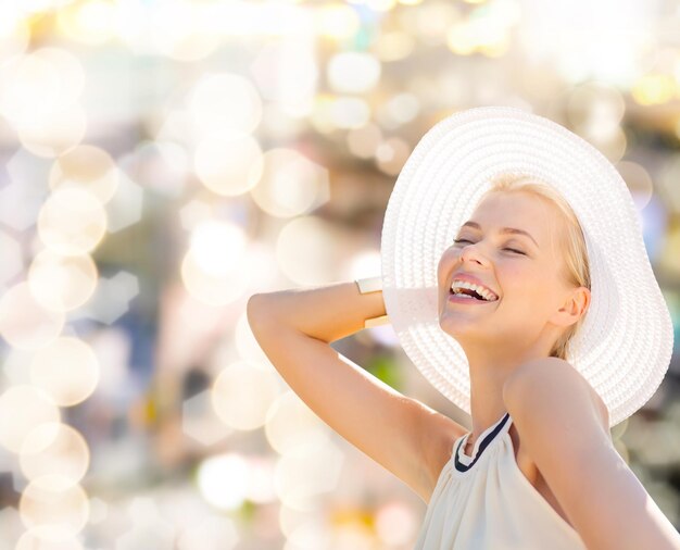 fashion, happiness and lifestyle concept - beautiful woman in hat enjoying summer outdoors