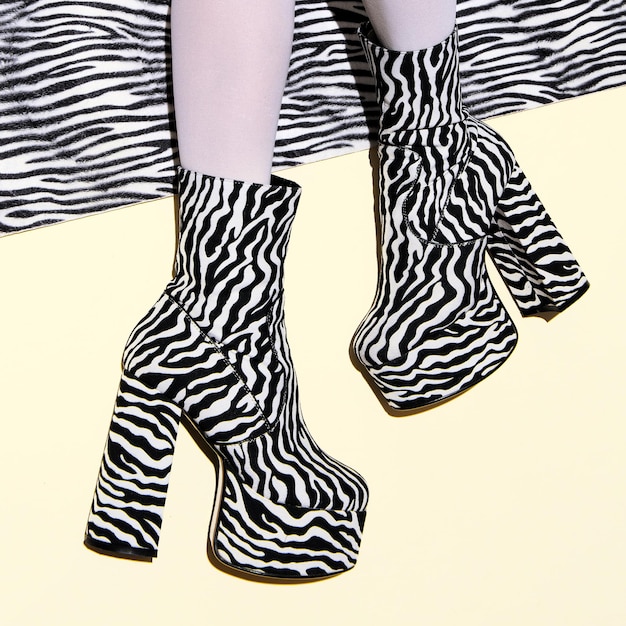 Fashion legs in heel party zebra boots on minimal background