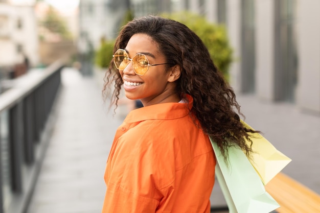 Fashion lifestyle Happy millennial african american lady customer in casual and glasses with many bags