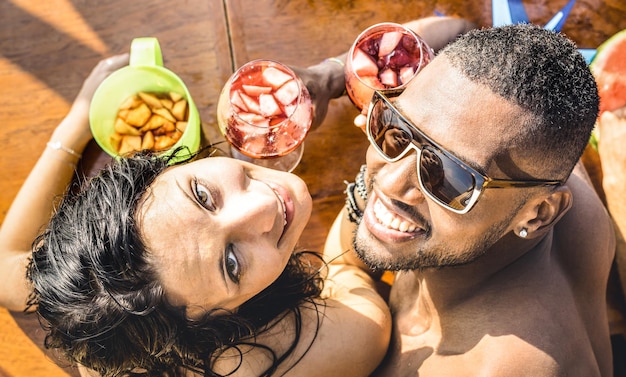 Fashion man and young woman having fun at cocktail bar drinking sangria