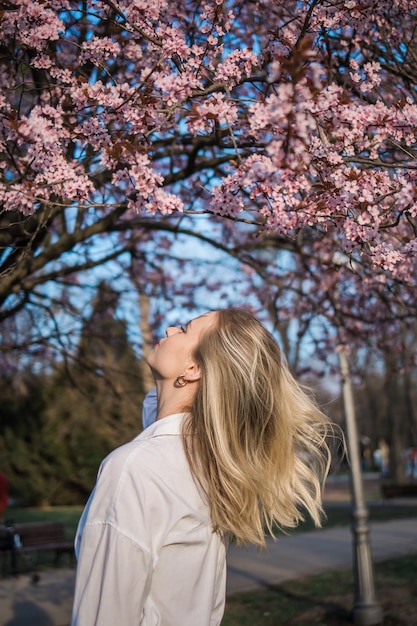 Photo fashion outdoor photo of beautiful woman with blond hair in elegant suit posing in spring flowering