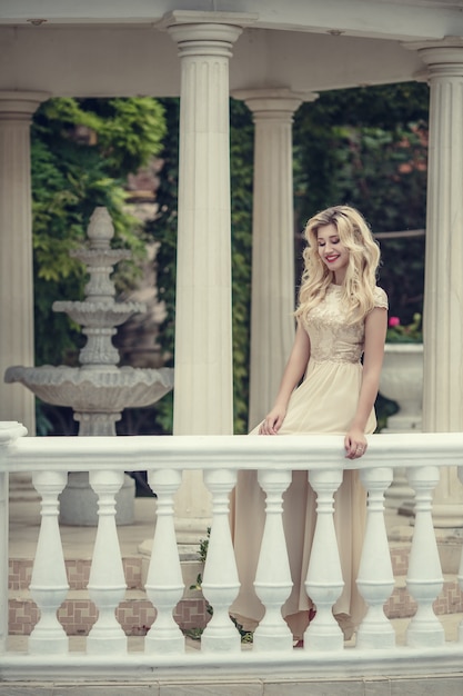 Fashion outdoor photo of elegant beautiful woman with blond hair in luxurious sequins dress ,posing in summer park