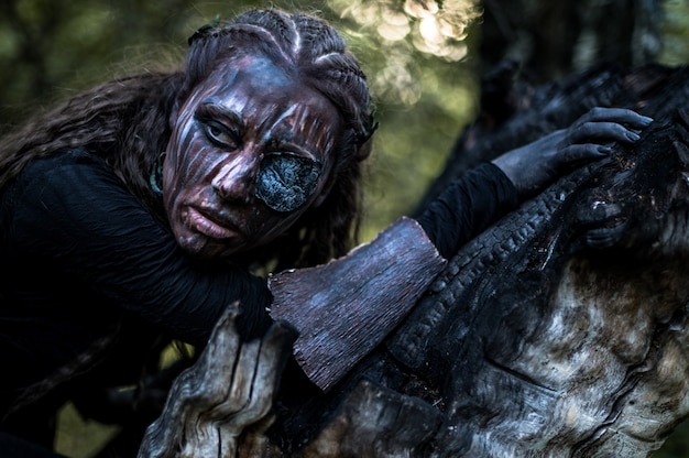 Fashion photo of woman with with creative make up in a forest. Fantasy.