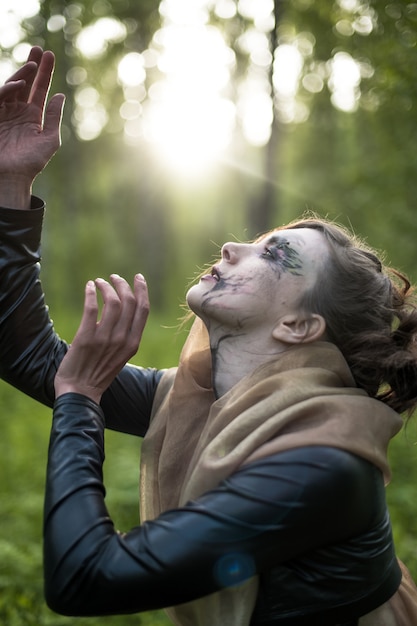 Fashion photo of woman with with creative make up in a forest. Fantasy.