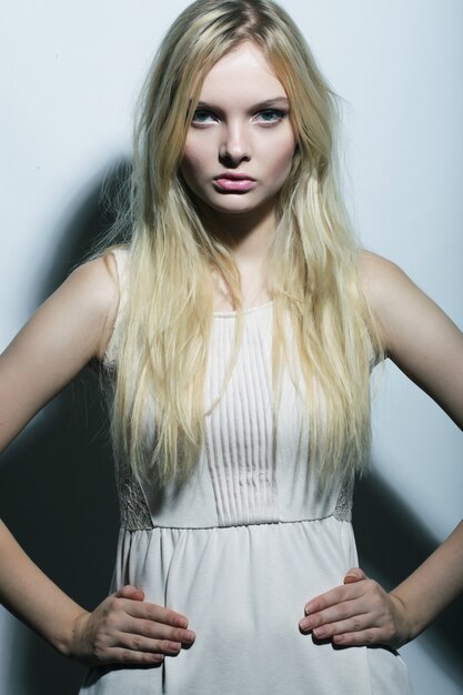 Fashion photo of young magnificent woman in white dress.