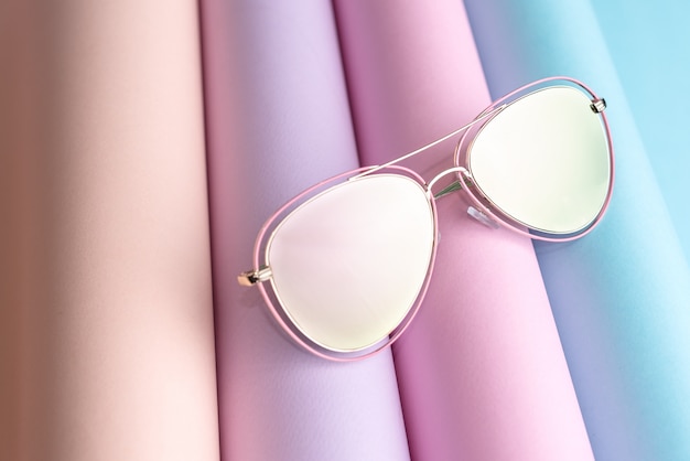 Fashion of pink Sunglasses put on colorful paper background