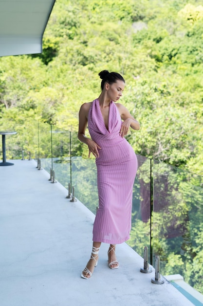 Fashion portrait of beautiful brunette woman posing in stylish evening dress outdoor natural daylight