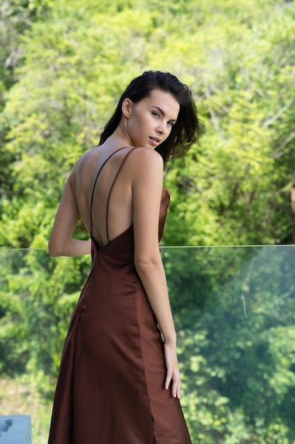 Fashion portrait of beautiful brunette woman posing in stylish evening dress outdoor natural daylight