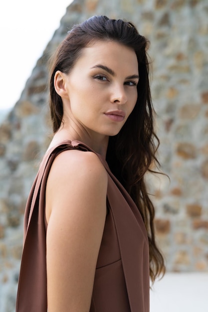 Fashion portrait of beautiful brunette woman posing in stylish evening dress outdoor natural daylight