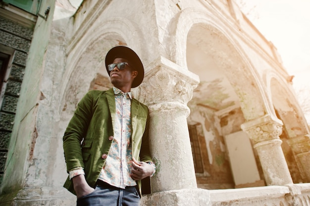 Fashion portrait of black african american man on green velvet jacket and black hat