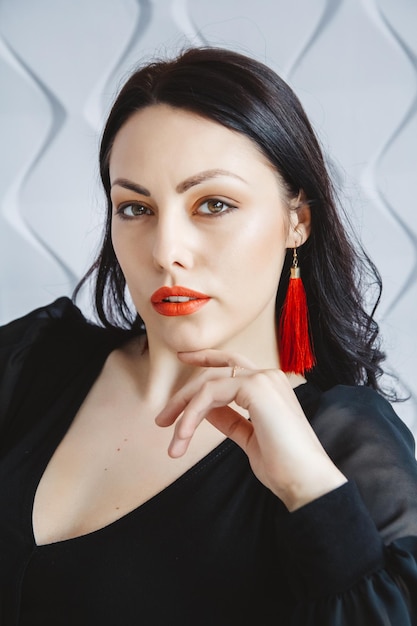 Fashion portrait of a stylish brunette woman wearing a black dress