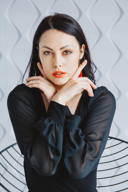 Fashion portrait of a stylish brunette woman wearing a black dress