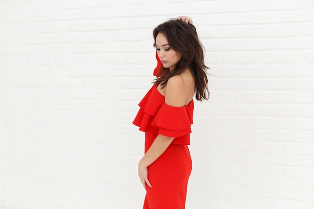 Fashion portrait of woman in red dress on light background