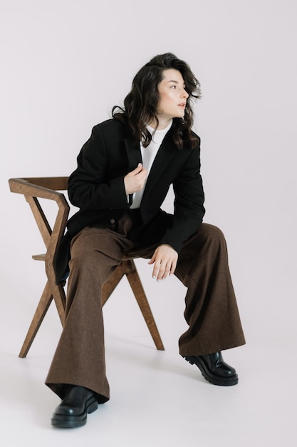 Fashion portrait of a woman with a model look without emotions Stylish image of a young businesswoman director or manager creative woman dressed in stylish office clothes pants and jacket