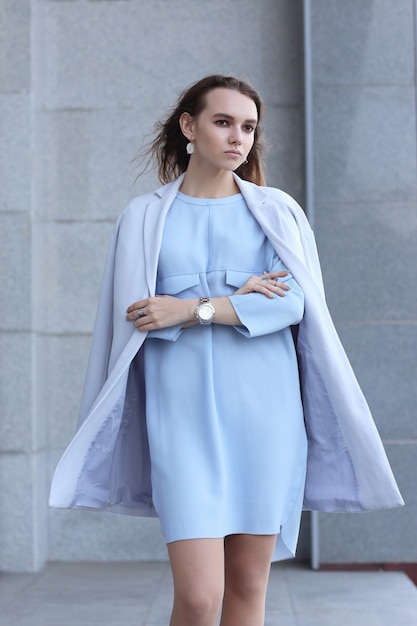 Fashion portrait of young elegant woman outdoor in jacket, dress, glasses. Trendy fashion look