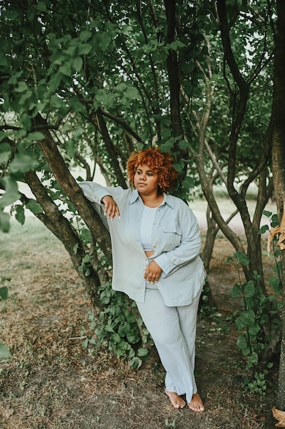 Fashion portrait of young naturally beautiful plus size african american woman in light trouser suit