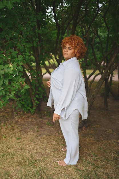 Fashion portrait of young naturally beautiful plus size african american woman in light trouser suit