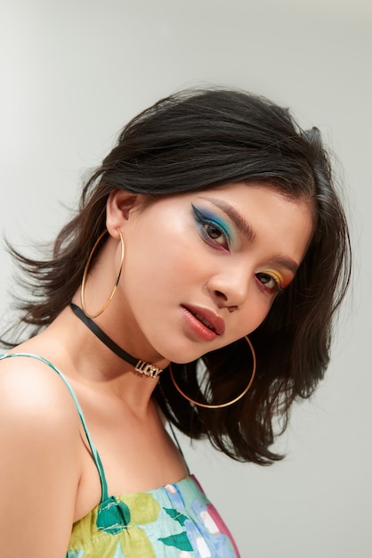 Fashion shot. Portrait of a beautiful young woman in trendy makeup with rainbow eye arrows. Make-up and cosmetics.