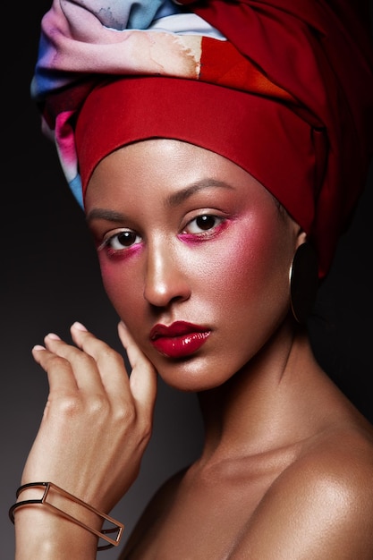 Fashion studio portrait of beautiful african american woman with perfect smooth glowing mulatto skin make up